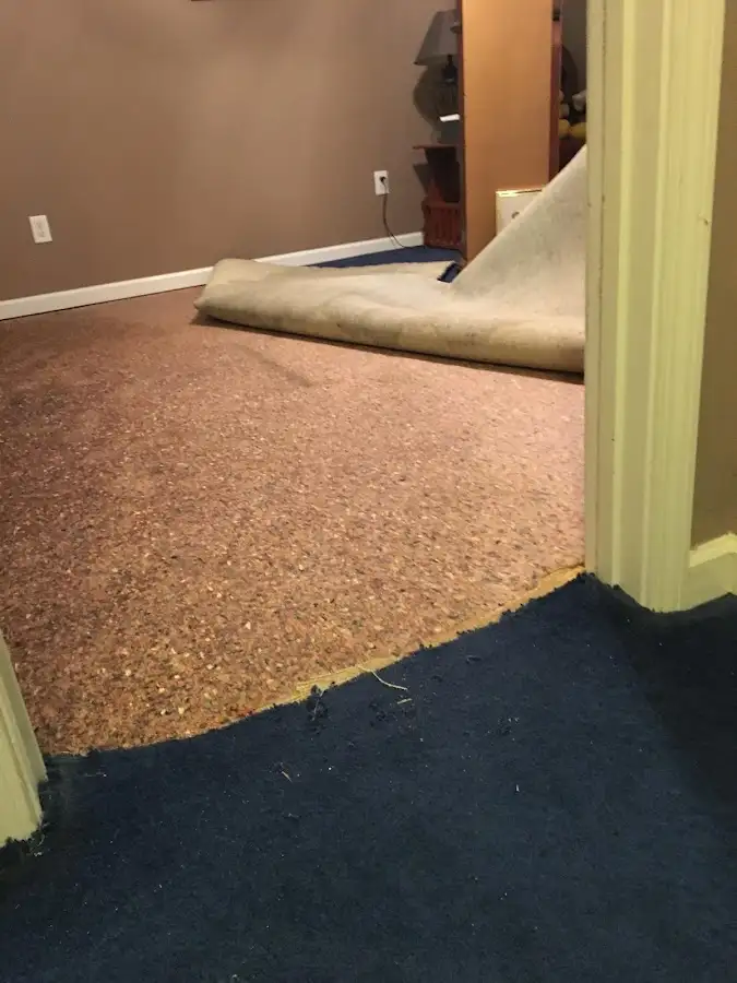 Carpet pad removal revealing water damage during Water Mitigation Services in Little Rock